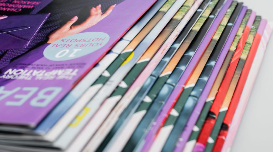 close up view of colorful magazines collection isolated on grey,stock image